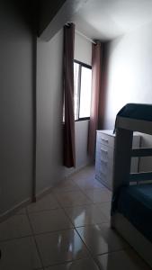 1 dormitorio con cama y ventana en Apartamento Ponta das Canas, en Florianópolis