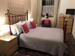 una camera da letto con un letto con cuscini rossi e una finestra di Atlas Guest House a Edimburgo Altre 37 foto