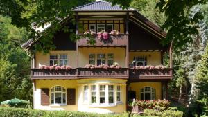 een geel huis met bloemen op het balkon bij Villa Liliengrund in Eisenach