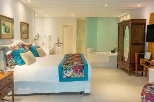 Locanda della Mimosa في بتروبوليس: غرفة نوم بسرير كبير وحوض استحمام