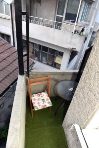 una silla sentada en un balcón con una mesa en City apartments, en Varna