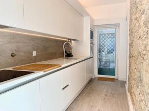 una cocina blanca con armarios blancos y fregadero en Home Out City Villa, en Lisboa