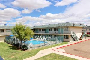 an exterior view of a building with a swimming pool at Motel 6-Tucumcari, NM in Tucumcari