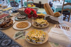 a table topped with plates of food and pastries at Hotel Acquamarina in Portoferraio