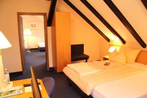 sypialnia z łóżkiem i biurkiem z krzesłem w obiekcie Hotel Klinger w mieście Plettenberg