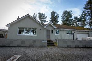 a white house with a fence in front of it at The Salmon Hut in Aberlour