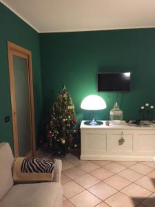 ein Wohnzimmer mit einem Weihnachtsbaum und einem TV in der Unterkunft Grazioso appartamento nel centro della Toscana in Poggibonsi