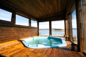 a large jacuzzi tub in a room with windows at RELAX Guest House in Tsigov Chark