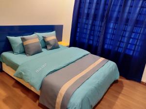 Schlafzimmer mit einem großen Bett und blauen Vorhängen in der Unterkunft WindMill SunRise PaddyView Homestay in Sekinchan