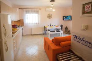 a kitchen and living room with a couch and a table at Konstantina & Evgenia Deluxe Apartment in Nea Peramos