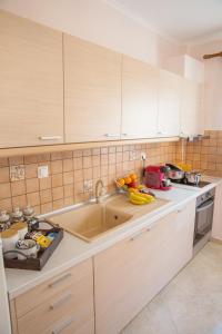 a kitchen with white cabinets and a sink at Konstantina & Evgenia Deluxe Apartment in Nea Peramos