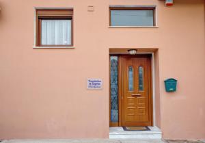 a orange building with a door and a sign on it at Konstantina & Evgenia Deluxe Apartment in Nea Peramos