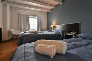 a bedroom with two beds with a towel on them at Hotel Bariloche Mountain in San Carlos de Bariloche