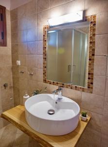 a bathroom with a white sink and a mirror at Konstantina & Evgenia Deluxe Apartment in Nea Peramos