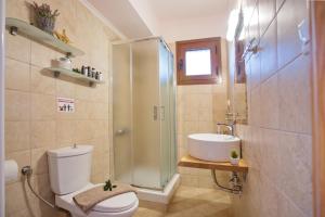 a bathroom with a shower and a toilet and a sink at Konstantina & Evgenia Deluxe Apartment in Nea Peramos