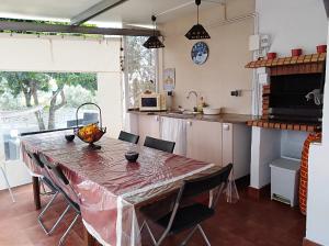 a kitchen with a table with chairs and a counter at Casa da Lameira in Serra