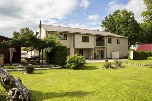 a large white house with a grass yard at Vahe Guest House in Põltsamaa