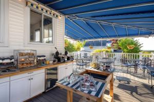 an outdoor kitchen with a blue awning on a patio at Glen Cove Inn & Suites Rockport in Rockport
