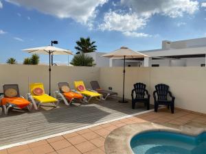 patio z krzesłami, basenem i domem w obiekcie Buganvilla 19 forever w mieście Playa Blanca