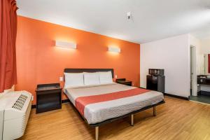 een slaapkamer met een bed met een oranje muur bij Motel 6-Westley, CA in Westley