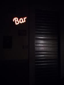 a bar sign is lit up in the dark at Thematic Rooms - AThema Atmosphere in Trieste