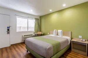 a bedroom with a bed with a green wall at Motel 6-Needles, CA in Needles
