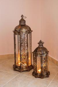 two lanterns are sitting on a tile floor at Konstantina & Evgenia Deluxe Apartment in Nea Peramos