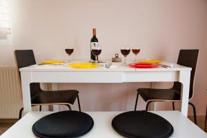 a table with two glasses of wine and two chairs at Konstantina & Evgenia Deluxe Apartment in Nea Peramos