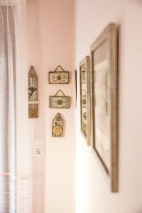 a wall with a bunch of framed pictures on it at Konstantina & Evgenia Deluxe Apartment in Nea Peramos