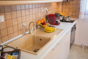 a kitchen counter with a sink with fruit on it at Konstantina & Evgenia Deluxe Apartment in Nea Peramos +36 photos