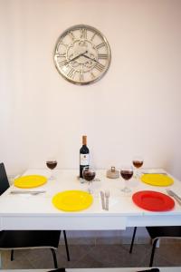 a table with yellow plates and a clock on the wall at Konstantina & Evgenia Deluxe Apartment in Nea Peramos