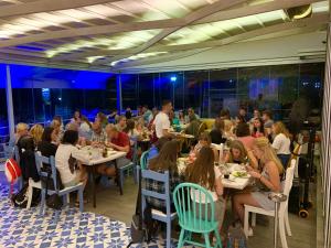 a group of people sitting at tables in a restaurant at Hotel Divers in Vlorë