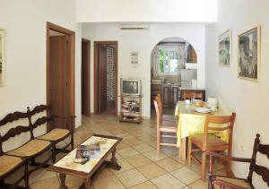 ein Wohnzimmer mit einem Tisch und Stühlen sowie eine Küche in der Unterkunft Ariti Apartments in Kassiopi