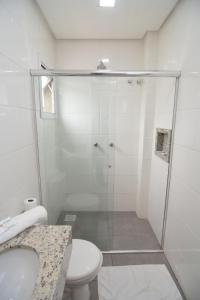 een badkamer met een douche, een toilet en een wastafel bij ID Hotel in Passo Fundo