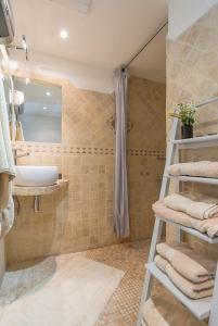 bagno con lavandino, doccia e asciugamani di Le Mas des Oules a Saint-Victor-des-Oules