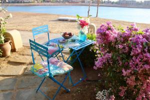 une table avec deux chaises et un vase de fleurs dans l'établissement Beit Matta, à Hurghada