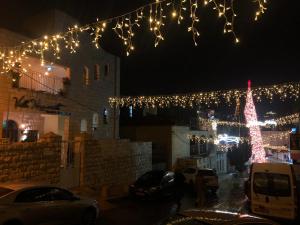 a christmas tree with lights in a city at night at Villa Nazareth B&B in Nazareth
