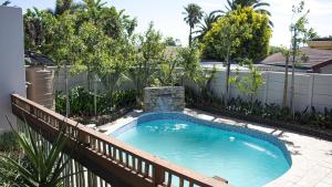 a swimming pool in a backyard with a fence at Princess Holiday Home in Cape Town