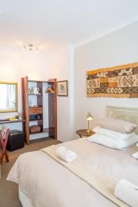 a bedroom with two beds and a desk at Stannards Guest Lodge 4 Star B&B, Knysna in Knysna