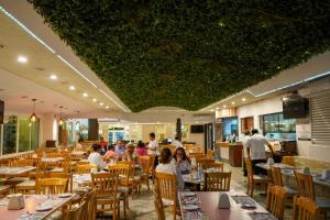 a dining room with people sitting at tables at Hotel Los Cocos Chetumal in Chetumal