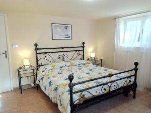 a bedroom with a black bed with a floral bedspread at Il Giardino di Patrizia in Querceta