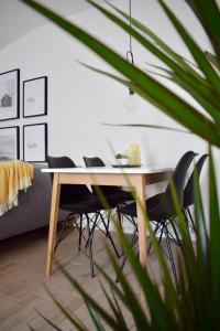 a dining room table with black chairs and a plant at VOYA NORDIC Apartment-a luxury oasis in the old town in Braşov