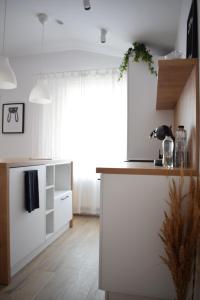 a kitchen with white cabinets and a large window at VOYA NORDIC Apartment-a luxury oasis in the old town in Braşov