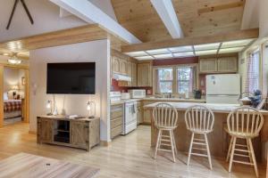 a kitchen with two bar stools and a tv at Snowpeak Chalet in Tahoe Donner in Truckee