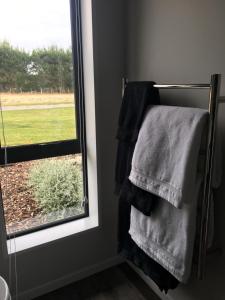 a bathroom with a towel rack and a window at Sandy Acre in North Loburn