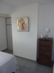 エンプリアブラバにあるParaiso Mar y Solの白い壁に絵画が描かれたベッドルーム