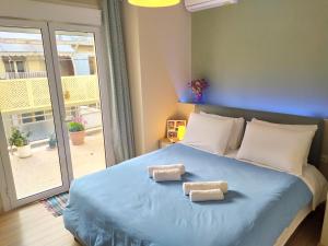 1 dormitorio con 1 cama azul y 2 toallas en Renovated apartment close to Exarchia square en Atenas