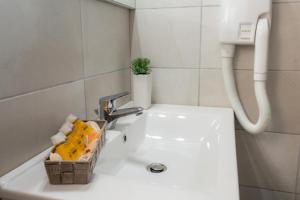 a bathroom with a sink with a basket on it at Studios Koula 2 - KORINA in Potos +24 photos