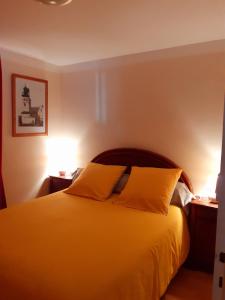Saint-Père-en-RetzにあるGite l'Imprévuのベッドルーム1室(黄色いシーツとランプ2つ付)