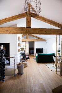 ein Wohnzimmer mit Holzbalken und einer grünen Couch in der Unterkunft Gîte de l'Autre Jardin in Mirepoix